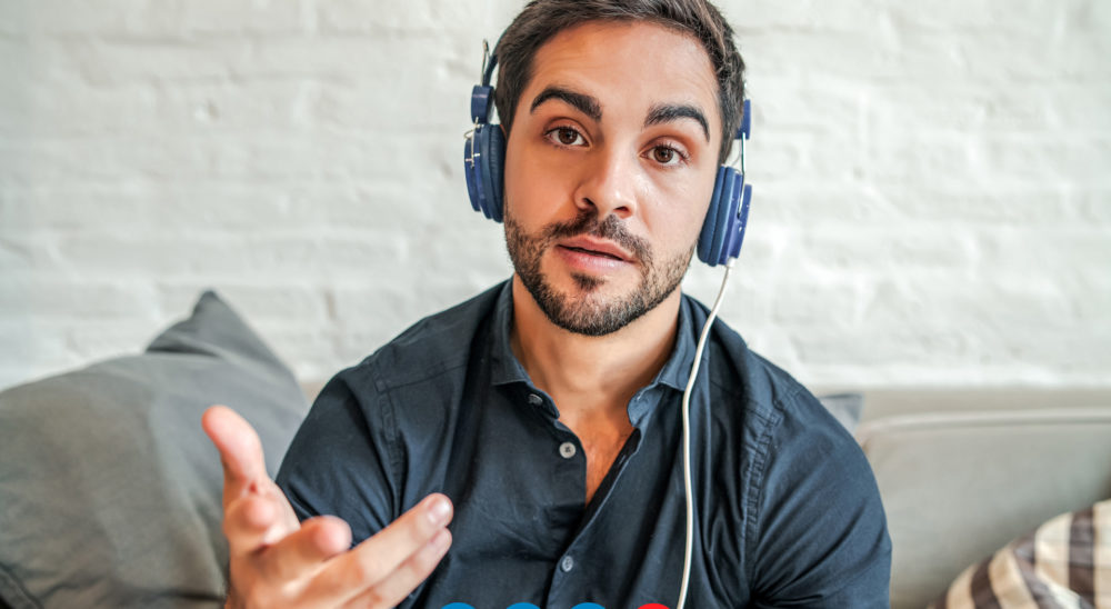 A man is wearing headphone and try to showing he want to talk to you.