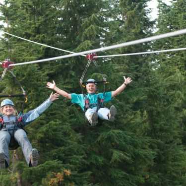 There are two guys whcih playing the rope hanging games and they are exited.